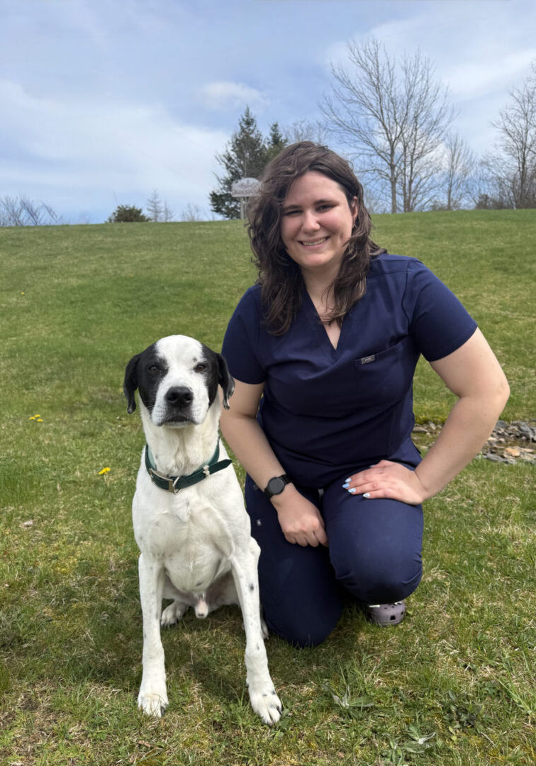 Woman kneeling on grass with dog