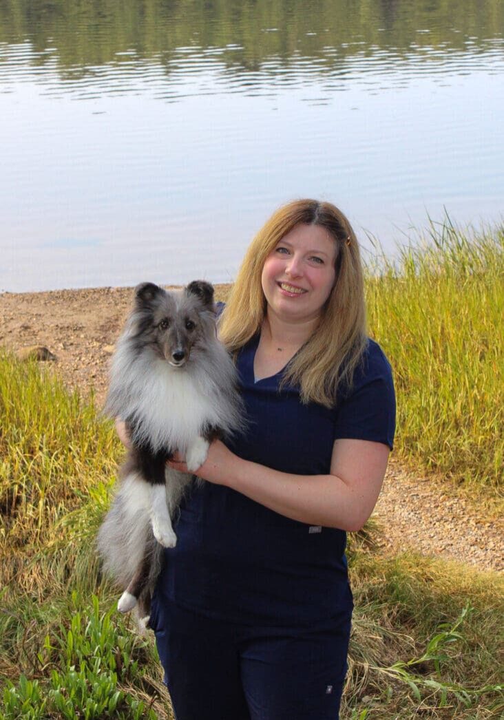 A woman holding a dog in her arms.